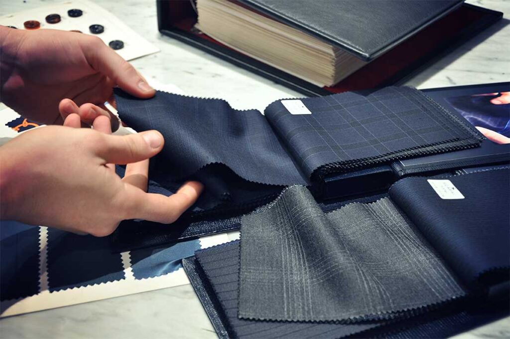 Michael Andrews Tailoring Process - Tailor selecting fabric swatches for custom suit design