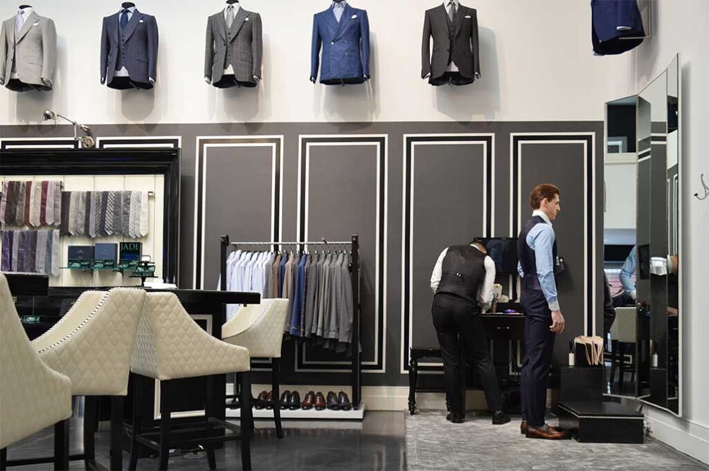 Tailor fitting client in suit showroom, Michael Andrews Tailoring Process