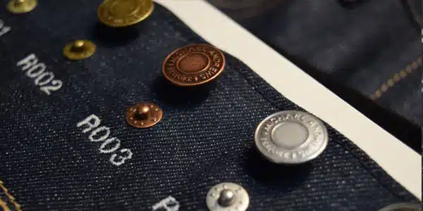 Assorted rivet styles labeled on denim fabric