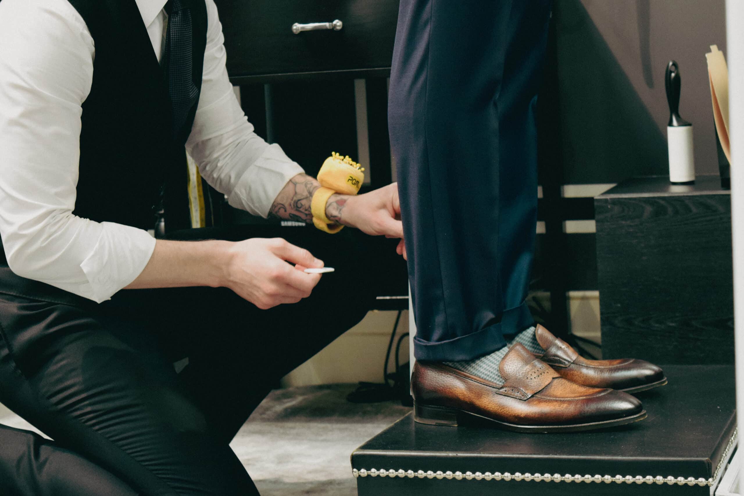 Bespoke vs. made to measure, Tailor measuring trouser hem in fitting session Bespoke vs. made to measure, Tailor measuring trouser hem in fitting session - custom suits nyc bespoke tailor midtown, noho