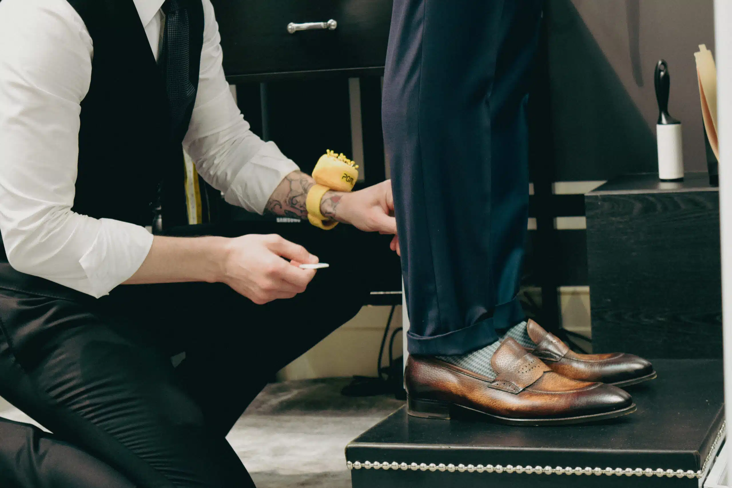 Bespoke vs. made to measure, Tailor measuring trouser hem in fitting session