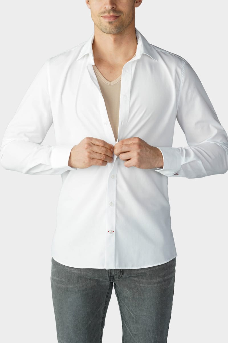 Model in a white shirt buttons up over a beige undershirt