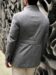 Back view of a light grey field jacket with down backing, showing the structured back design