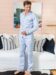 (product) Light Blue Stripe Pajama Pants, worn by a model standing in a cozy room