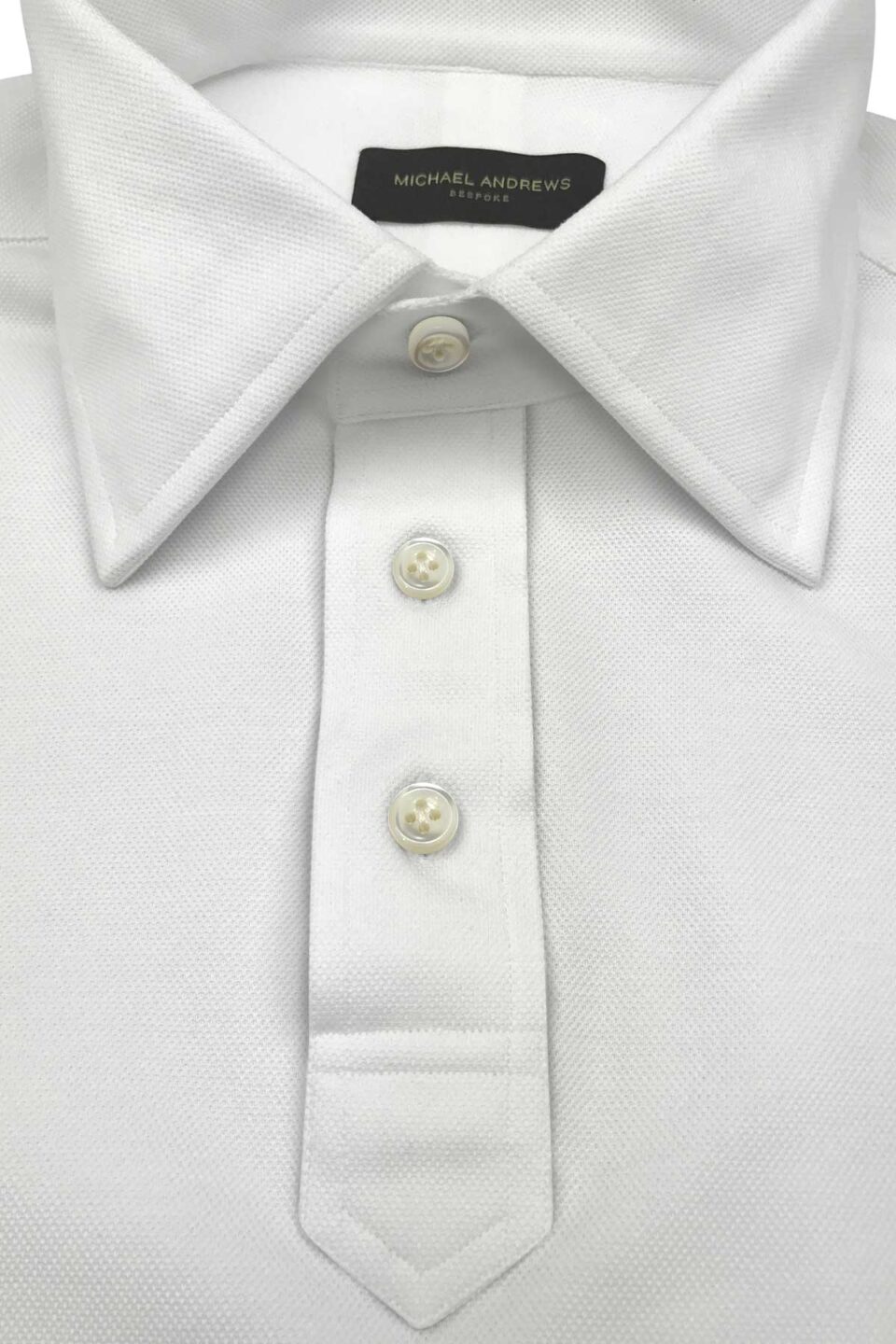 (product) White Pique Short Sleeve Polo Shirt, close-up of collar and buttons