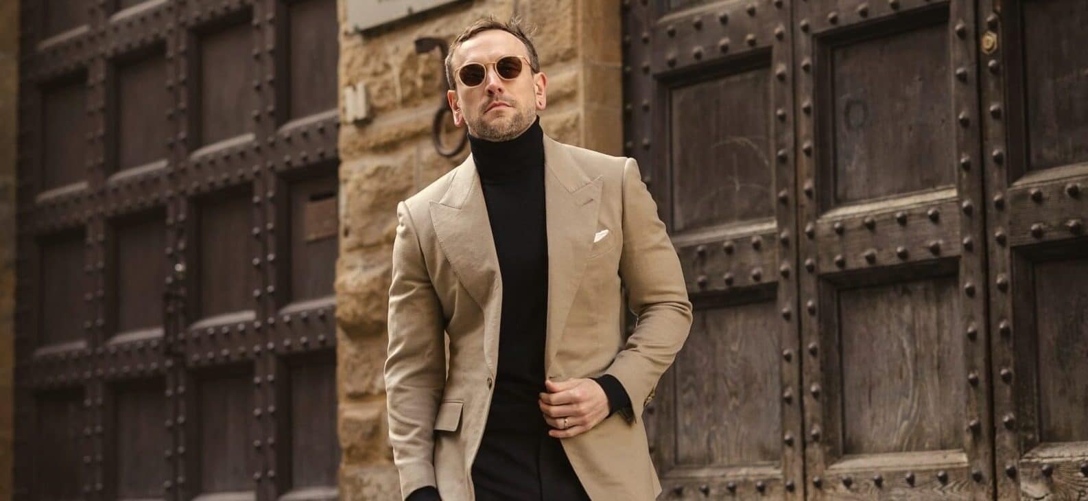 Model wearing tan blazer and black turtleneck sweater