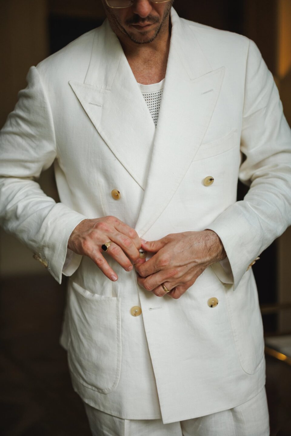 Close-up view of Cory in an off white linen suit