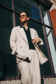 Cory in a beige double-breasted suit paired with a black open-collar knit shirt and sunglasses - custom suits nyc bespoke tailor midtown, noho