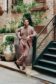 Shane wearing a dusty rose blend suit paired with a taupe crewneck tee and loafers, styled casually by Michael Andrews Bespoke in a garden alley setting