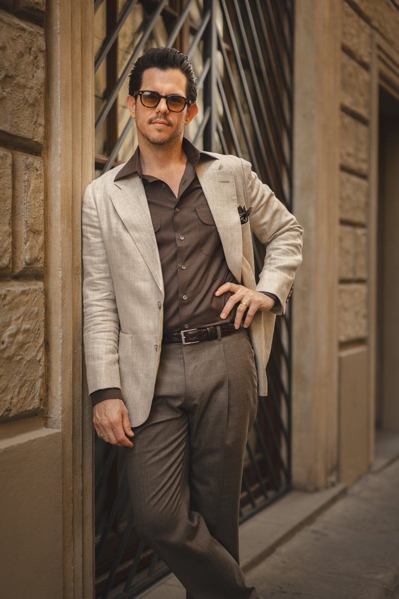 Cory wearing a tan linen sport coat with a brown shirt and trousers