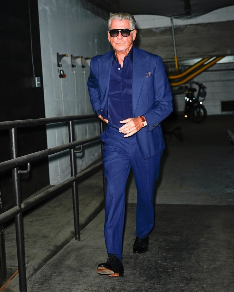 Pierce Brosnan in a bold cerulean blue suit and sunglasses arriving at The Tonight Show—sleek, confident, and Bond-level cool.