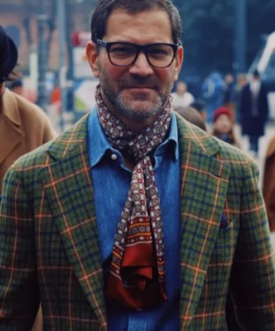 Pitti Uomo GQ-style street look with a green plaid tailored jacket, denim shirt, patterned scarf, and rust trousers in Florence.