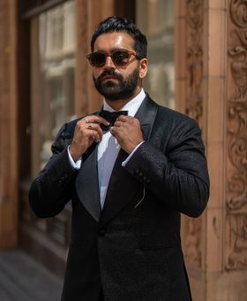 Rikesh Chauhan wearing a black tuxedo in Dormeuil Celebration for Look No. 15 of Michael Andrews Bespoke’s 20 for 20 anniversary lookbook.